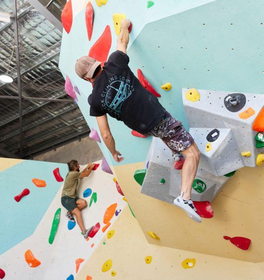 Climber working a problem on the slab wall at Ascend Bouldering
