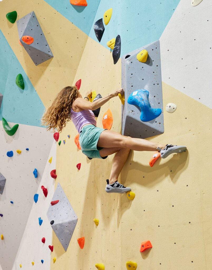 Climber stretching for a hold at Ascend Bouldering, Coffs Harbour